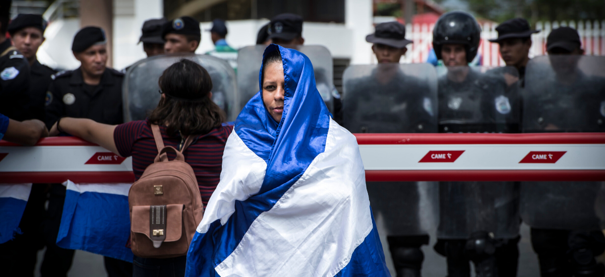 Una joven manifestante se cobija con la bandera azul y blanco, símbolo patrio y además de los opositores al gobierno de Daniel Ortega.